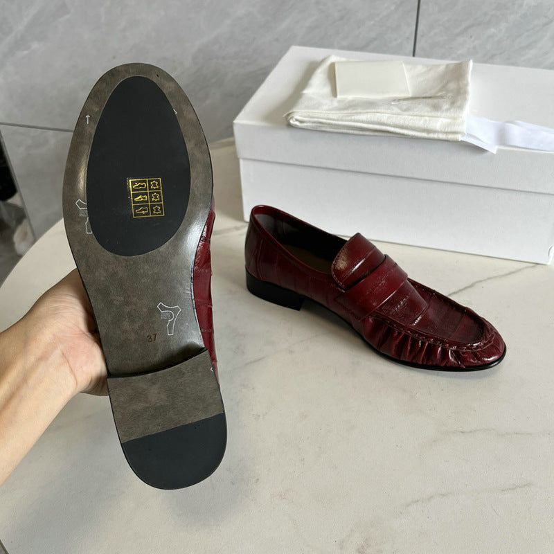 Rossie Viren eel skin women's loafers showing sleek black leather shoes with a low heel and classic slip-on design.