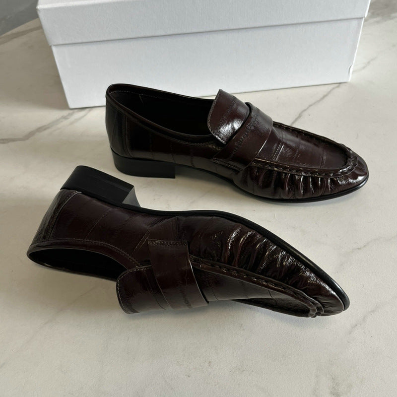 Eel skin loafers for women by Rossie Viren, stylish black shoes with slip-on design, smooth eel skin texture, and rounded toe.